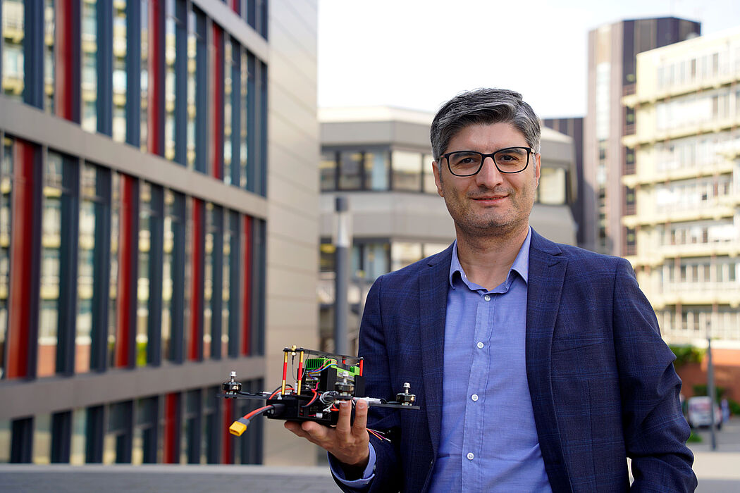 Prof. Dr. Erdal Kayacan mit einem Flugroboter auf dem Campus der Universit?t Padeborn.