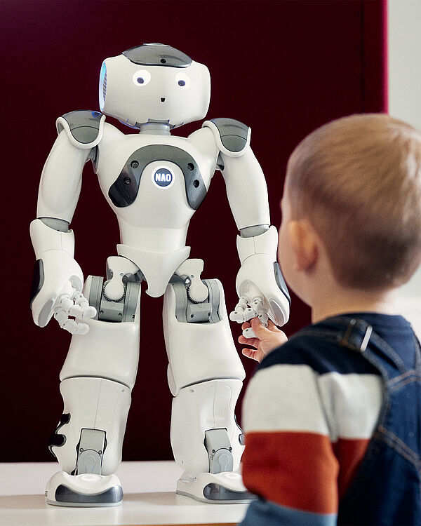 Ein Kind interagiert mit einem KI-Roboter.